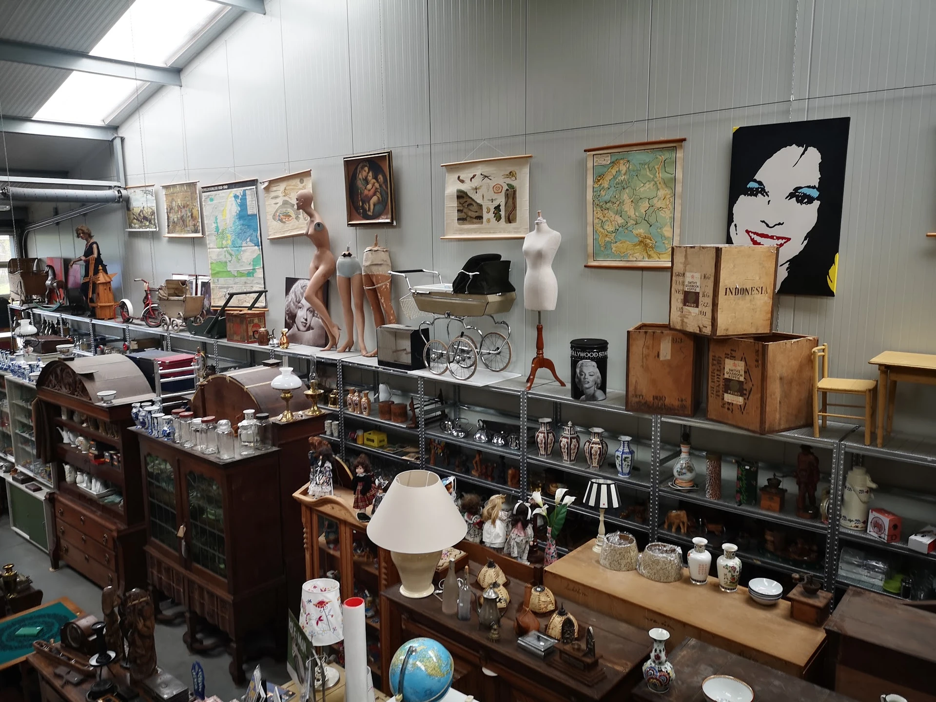 Winkelvloer met glazen vitrines vol diverse spullen, wanddecoratie en vintage items