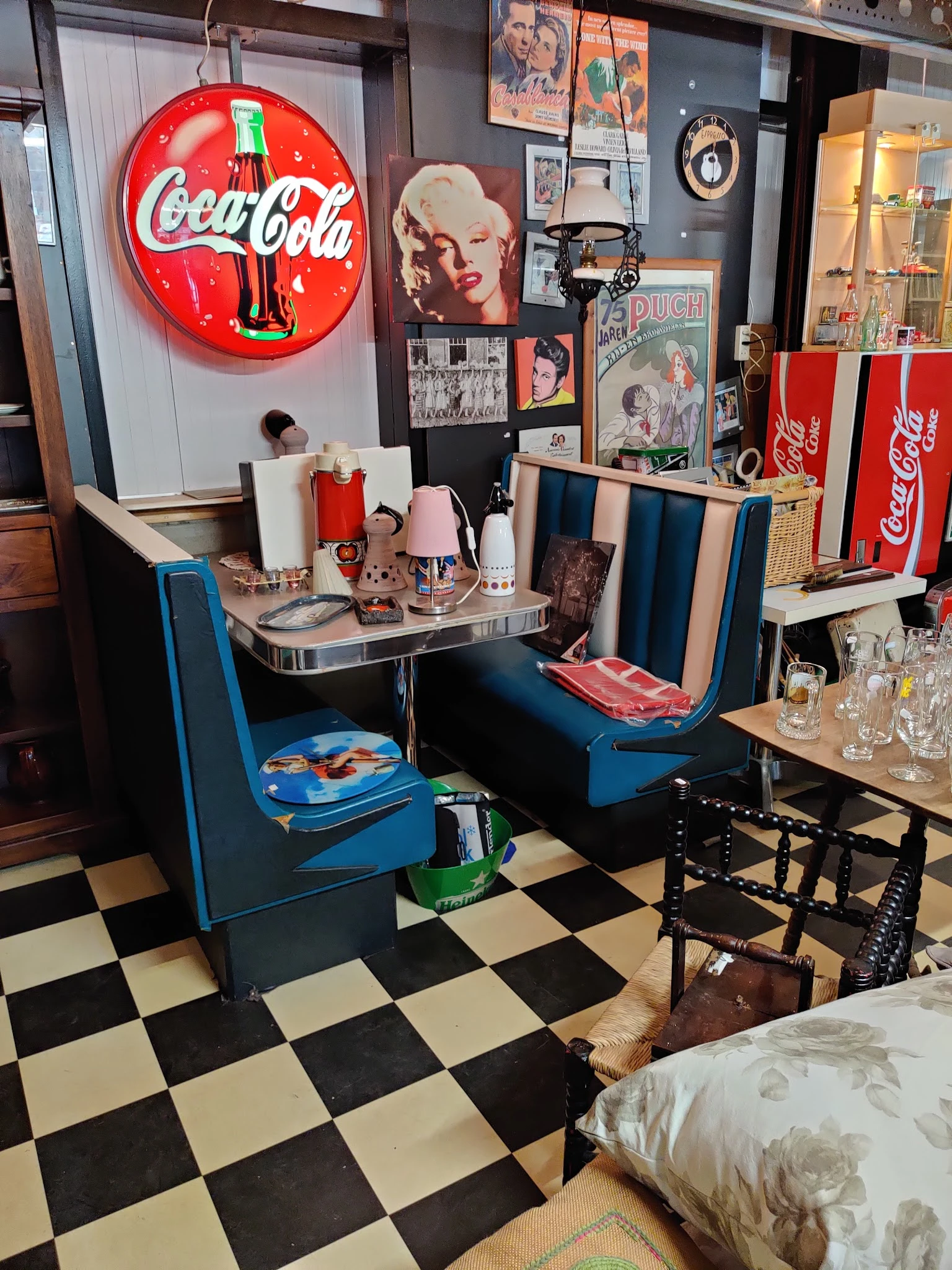 Vintage retro inrichtingsstijl met blauwe stoelen, een ronde tafel, Coca-Cola neonbord en nostalgische decoratie