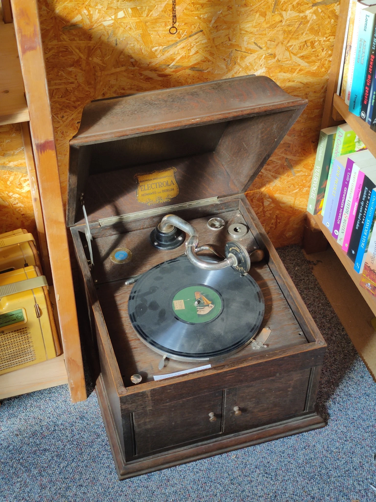 Vintage grammofoon in houten meubel met open deksel en draaitafel met plaat