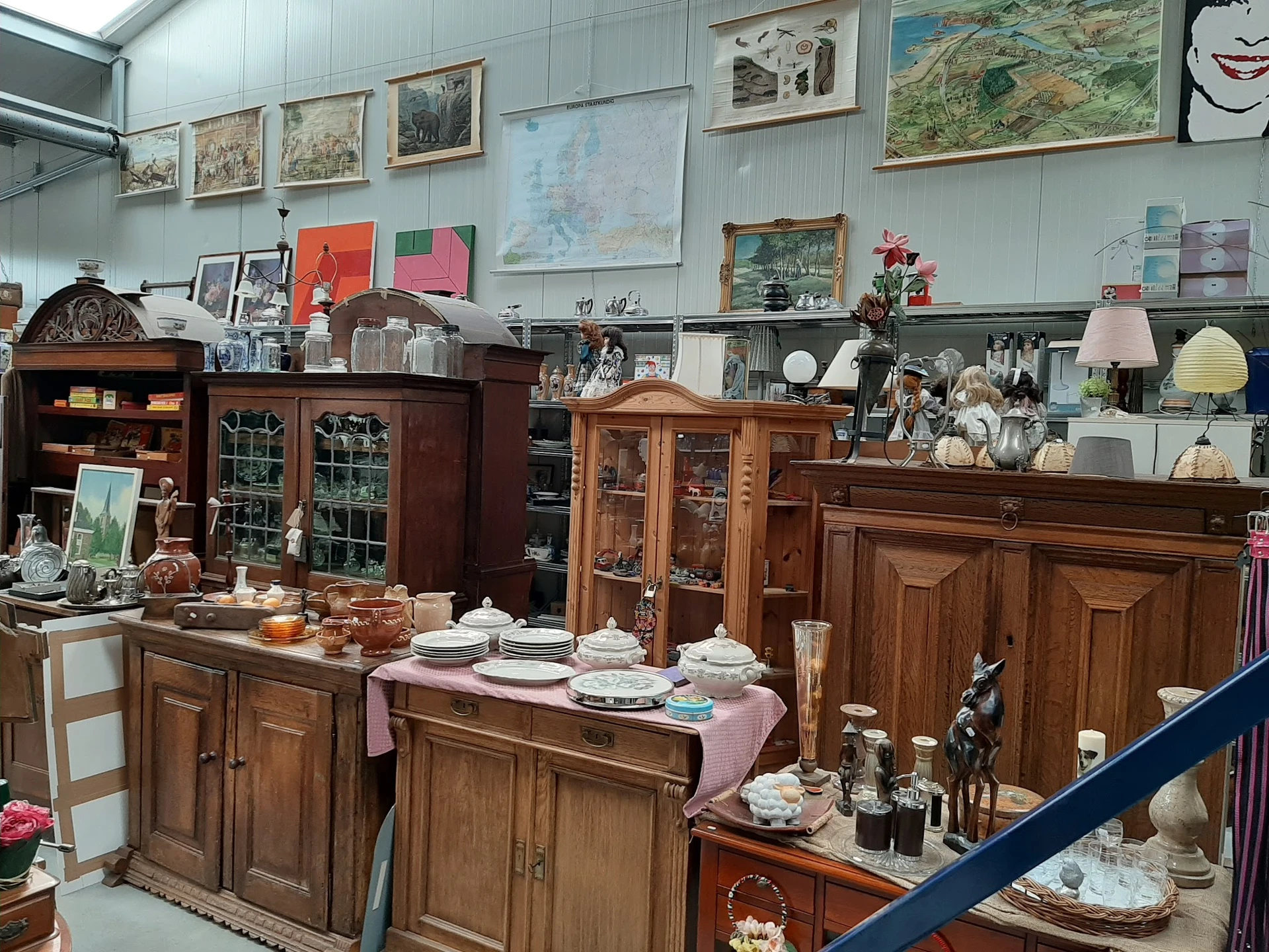Winkelvloer met houten kasten, vitrines en uitgestalde huishoudelijke artikelen, servies en decorstukken