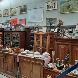 Winkelvloer met houten kasten, vitrines en uitgestalde huishoudelijke artikelen, servies en decorstukken