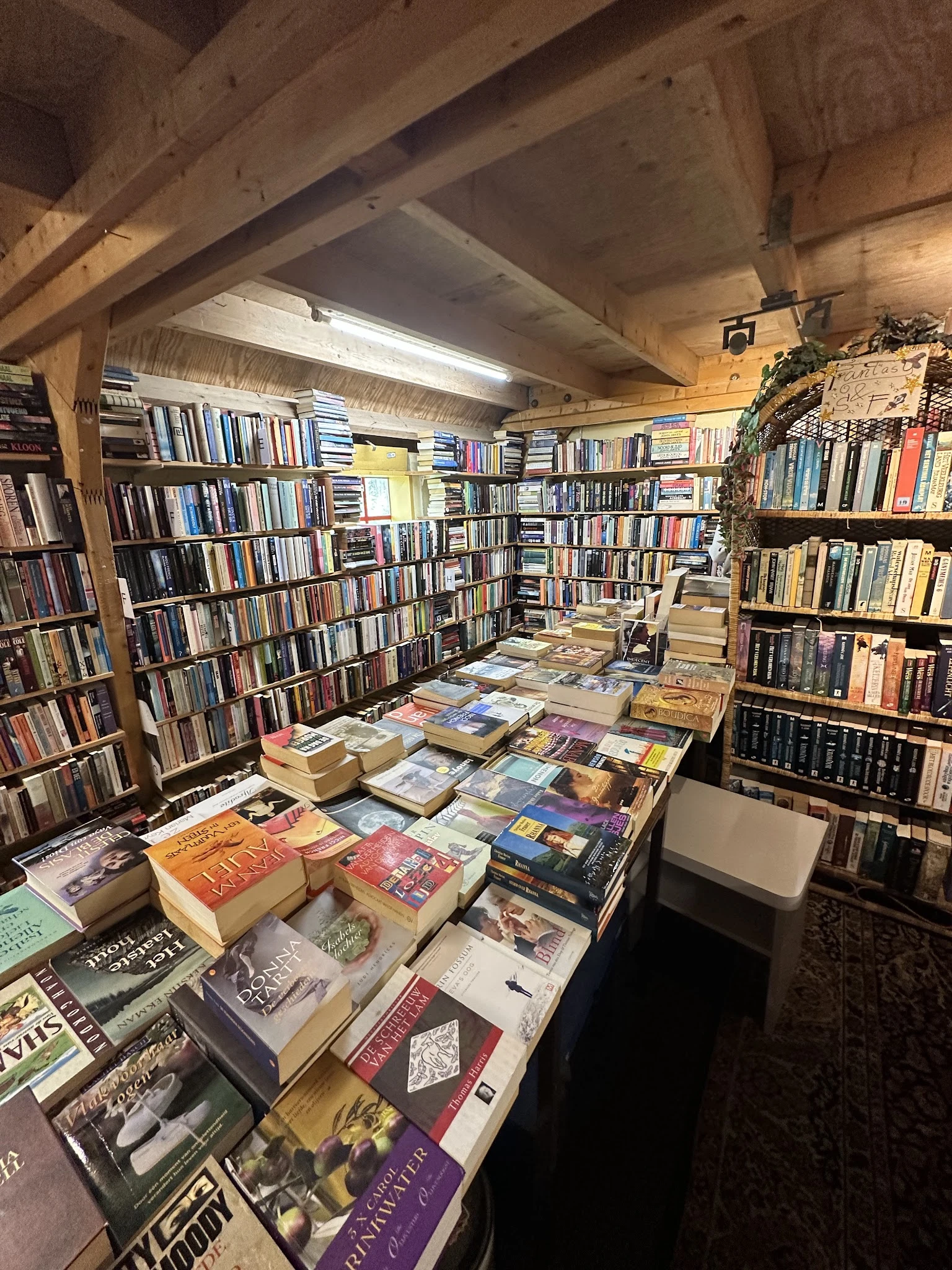 Boeken en dvd's uitgestald op dozen en stellingen in kringloopwinkel