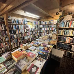 Boeken en dvd's uitgestald op dozen en stellingen in kringloopwinkel