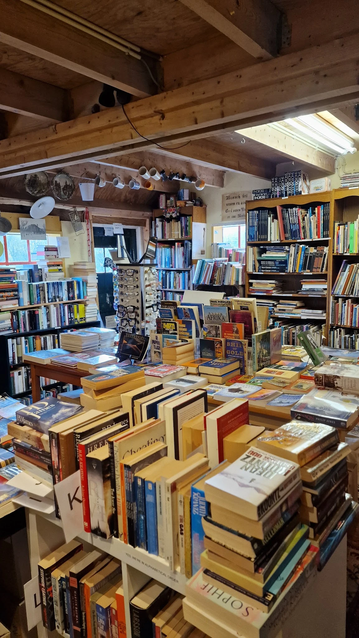 Binnenaanzicht van boekenwinkel met boeken op tafels en in kasten tegen de muren