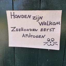 Handgeschreven welkomstbord met tekst in het Nederlands en een getekend katgezicht