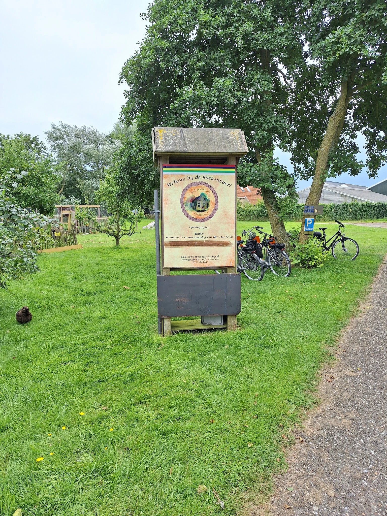 Informatiebord voor fietsers naast een pad met fietsen op de achtergrond