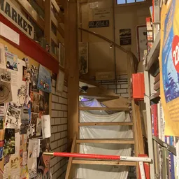 Trappenhuisgebied met versiering en posters aan muren, zicht op bovenverdieping