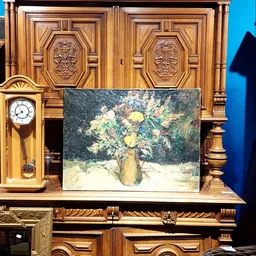 Schilderij met bloemen in vaas tegen donkere achtergrond, geplaatst tegen houten wand met wandklok
