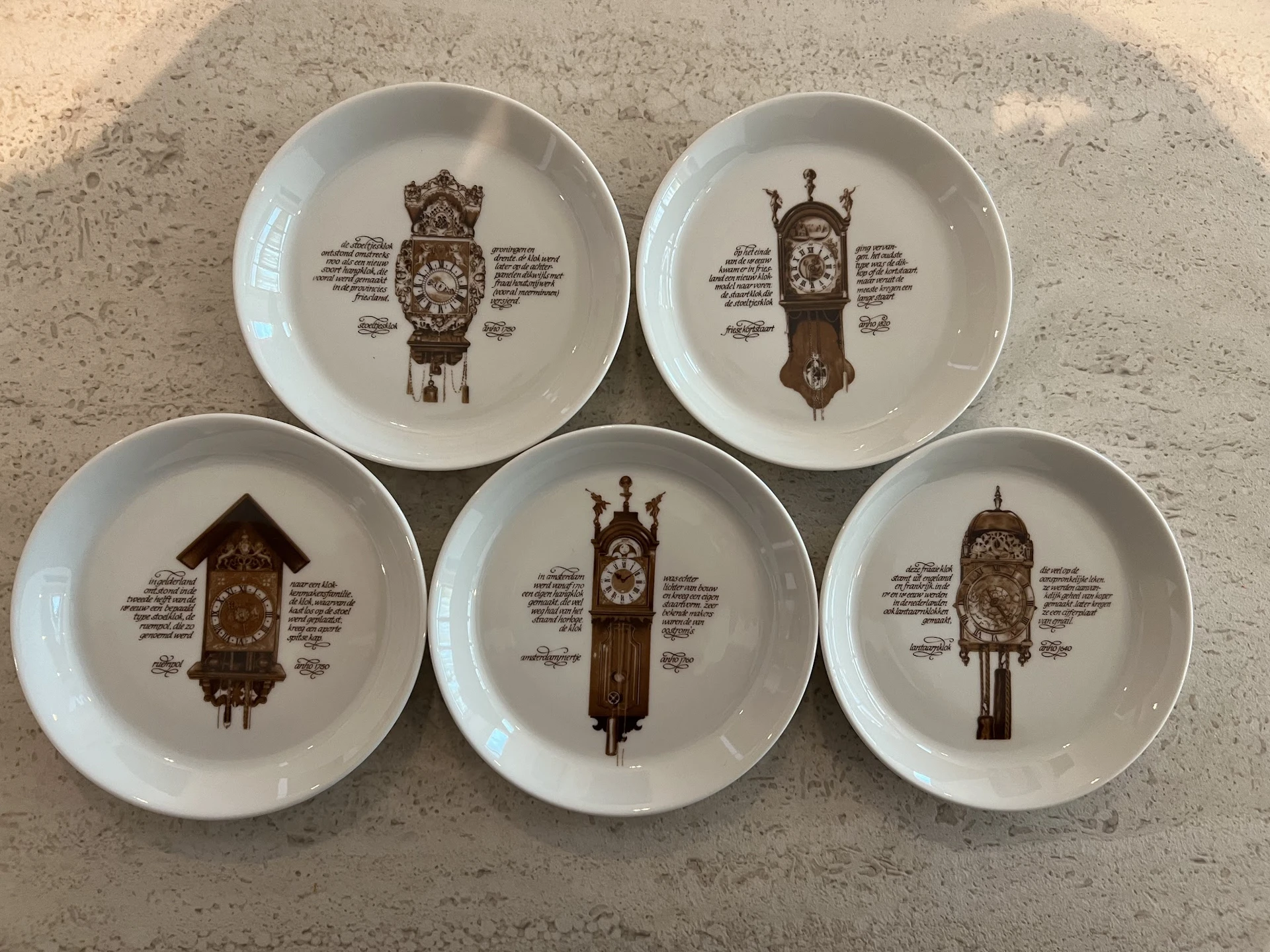 Vijf decoratieve borden met afbeeldingen van vintage koekoeksklokken en beschrijvende teksten