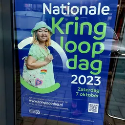 Promotieaffiche voor Kringloop dag 2023 op 7 oktober met foto van vrouw in groen shirt
