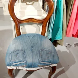 Houten stoel met blauwe jeansachtige bekleding en beschadigde zitting