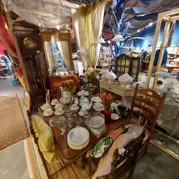 Uitgestalde serviesgoed, glazen en huishoudelijke artikelen op tafels in de winkel