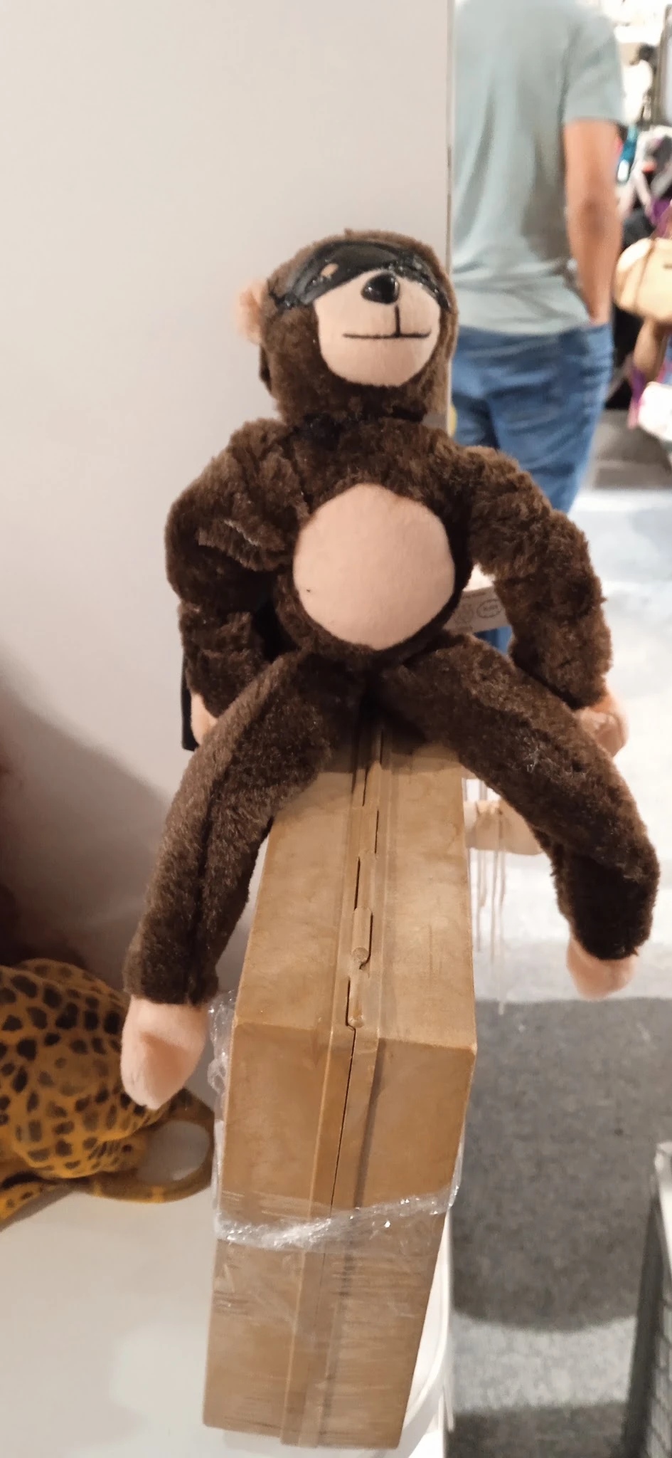 Bruine pluche knuffel met grote armen en beige buik, gehouden voor het gezicht