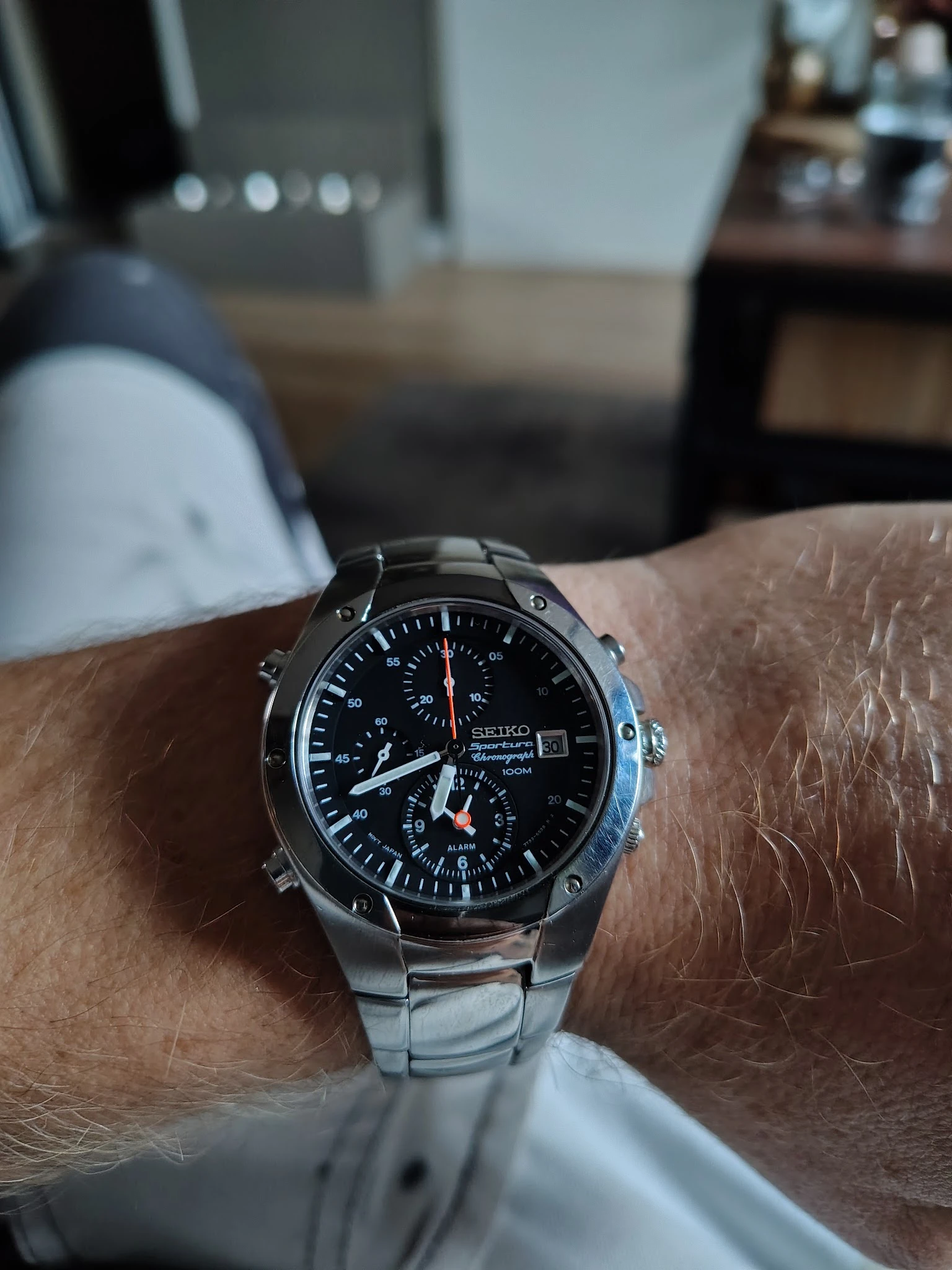 Close-up van een Seiko chronograaf horloge met zwarte wijzerplaat aan de pols van een persoon
