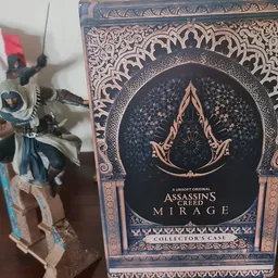 Assassin's Creed Mirage Collector's Case met logo en decoratieve elementen, naast een actiefiguur