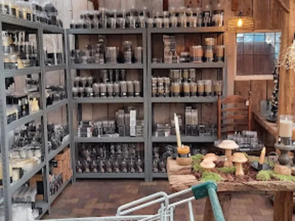 Winkelinterieur met grijze stellingen vol flessen en potten, houten tafel met decoratieve items op de voorgrond