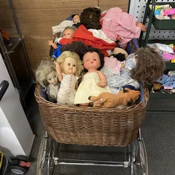 Mand met verzameling vintage poppen en speelgoed