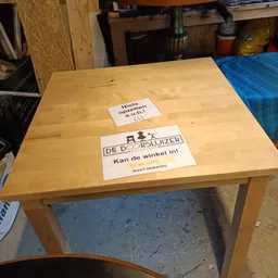 Houten tafel met twee witte labelstickers erop