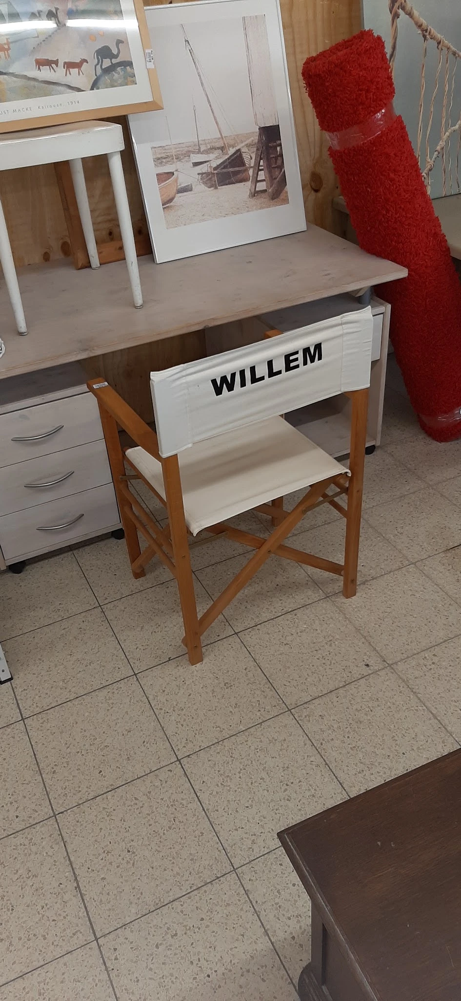 Witte regisseursstoel met houten frame en naam 'WILLEM' op de rugleuning