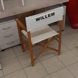 Witte regisseursstoel met houten frame en naam 'WILLEM' op de rugleuning