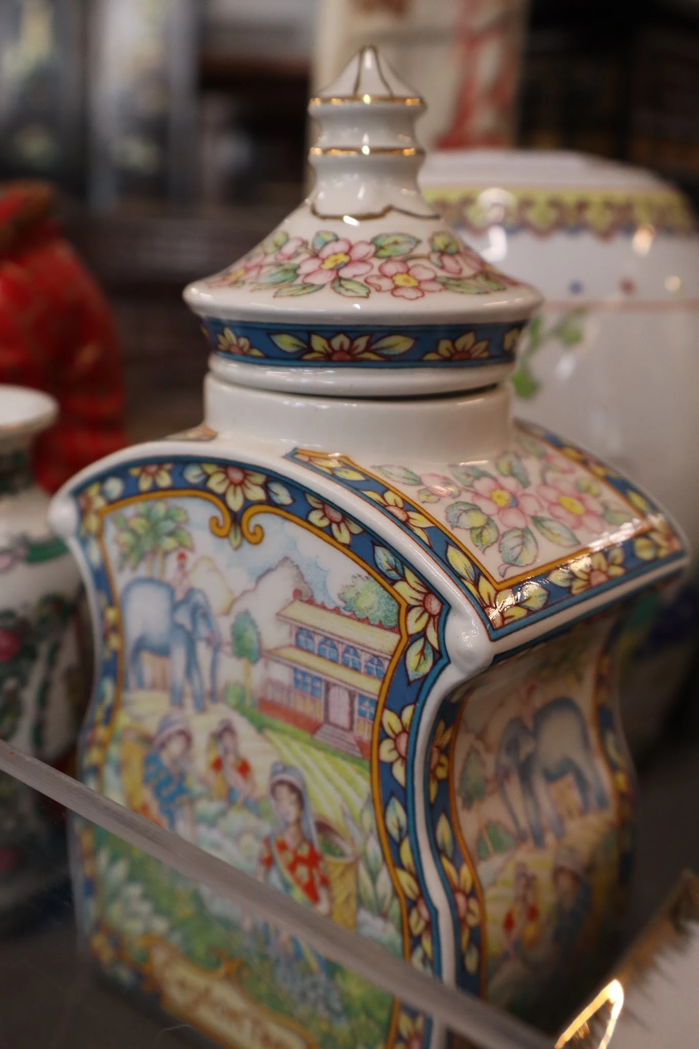 Close-up van een decoratief Chinees porselein potje met blauwe en gouden ornamenten en kleurige bloemmotieven