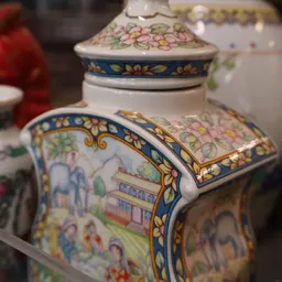 Close-up van een decoratief Chinees porselein potje met blauwe en gouden ornamenten en kleurige bloemmotieven