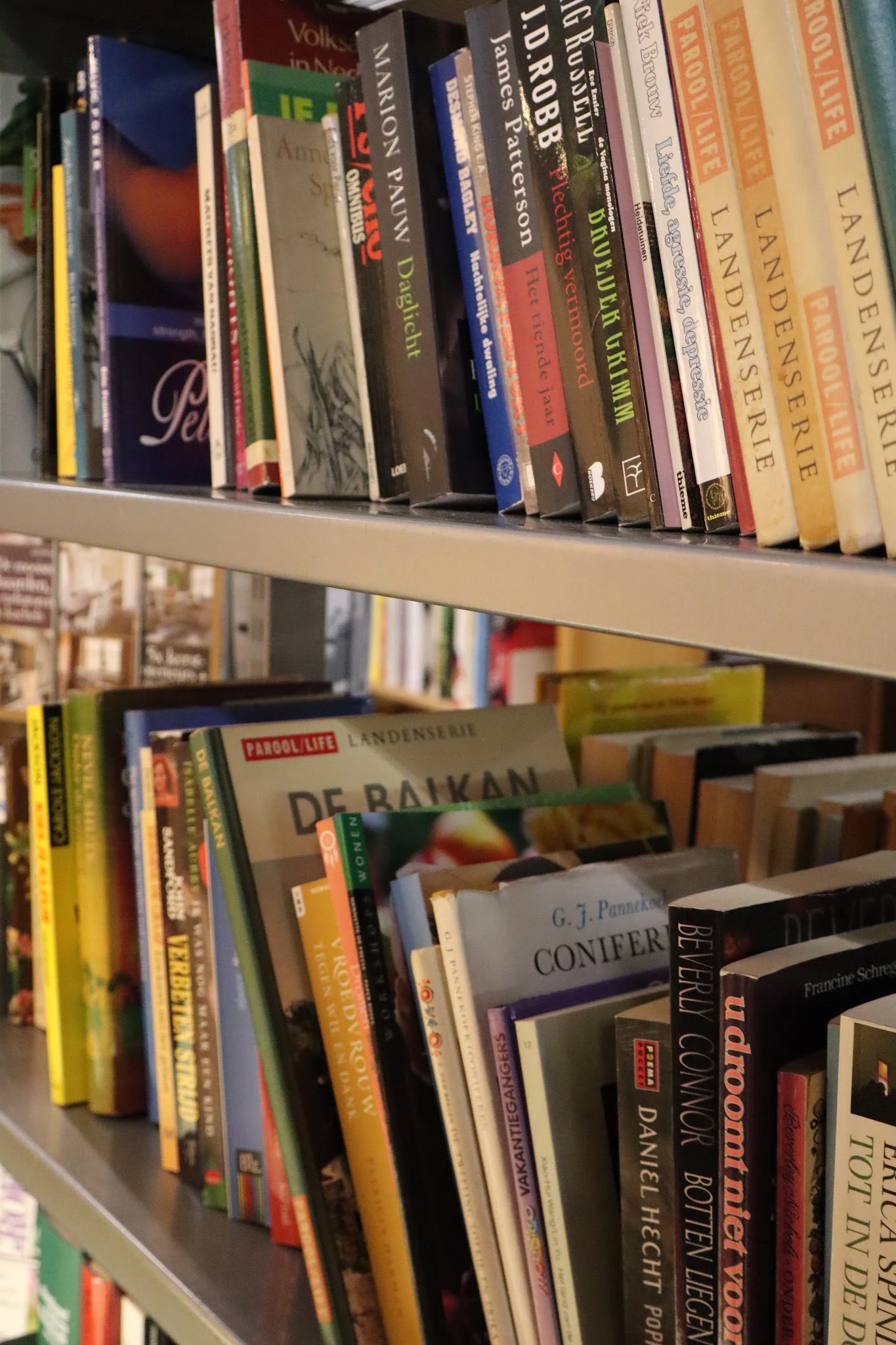 Boekenrekken met tweedehands boeken op meerdere planken in de winkel