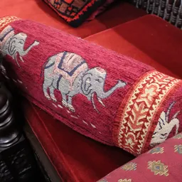 Close-up van een rood/bordeaux textiel met traditionele olifantenmotieven en decoratieve rand