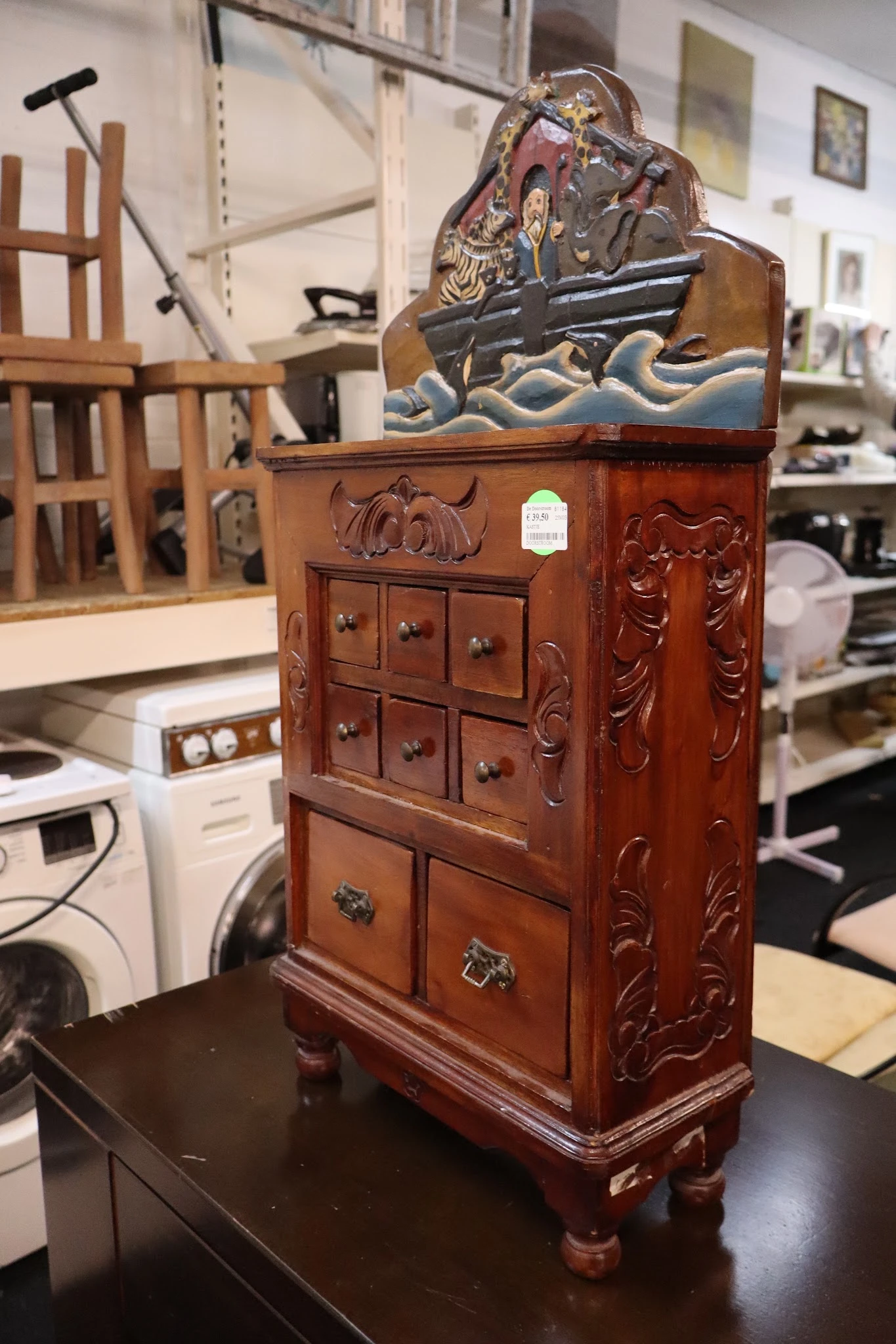 Houten kastje met gesneden decoratie en meerdere kleine laden met koperen handgrepen