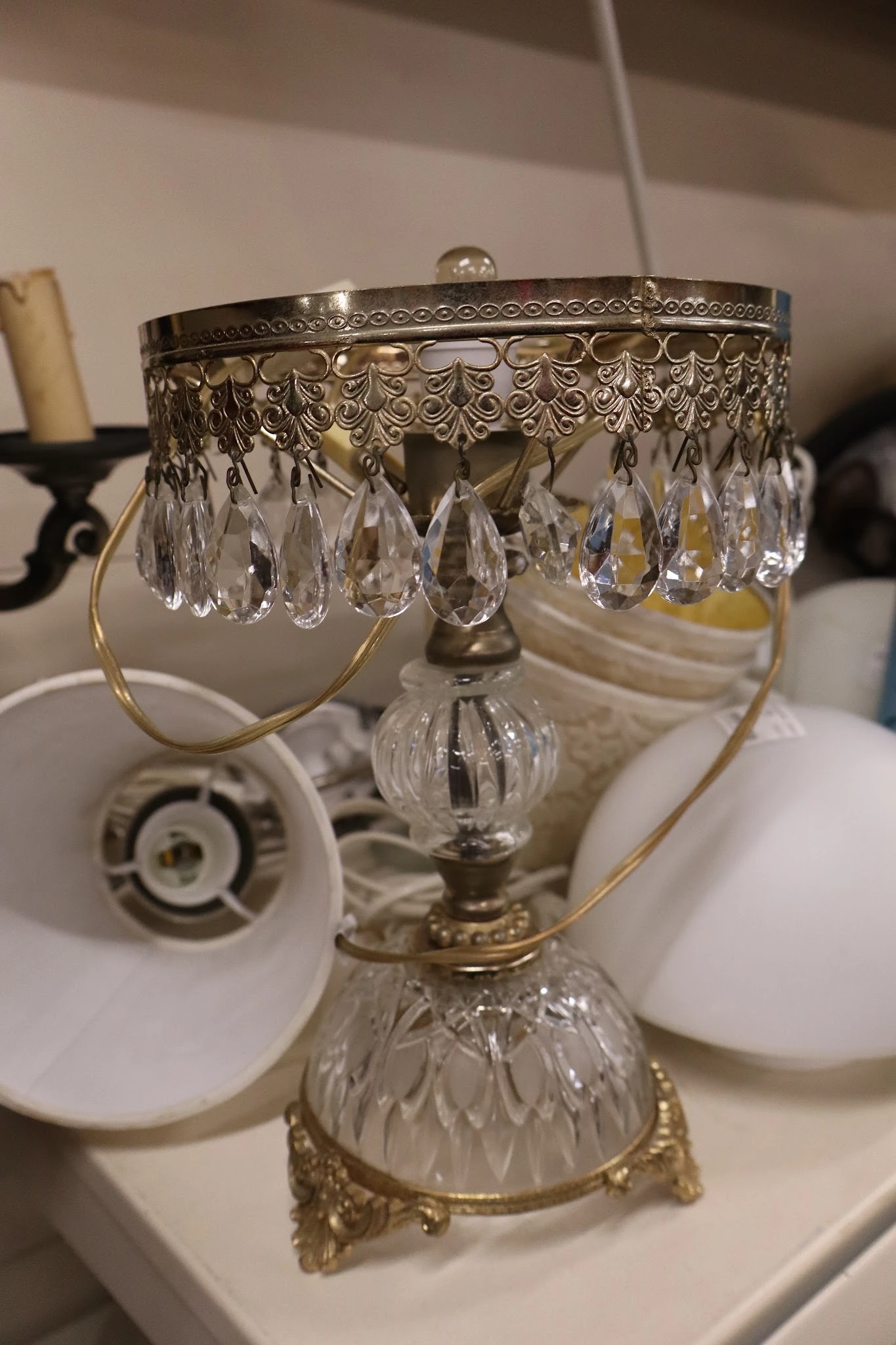 Close-up van een kristallen kroonluchter met hangende druppels en messing fitting