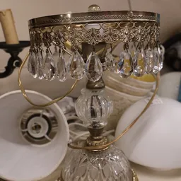 Close-up van een kristallen kroonluchter met hangende druppels en messing fitting