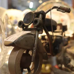 Close-up van een vintage scooter-speelgoedmodel met zwarte details en zadelkussen