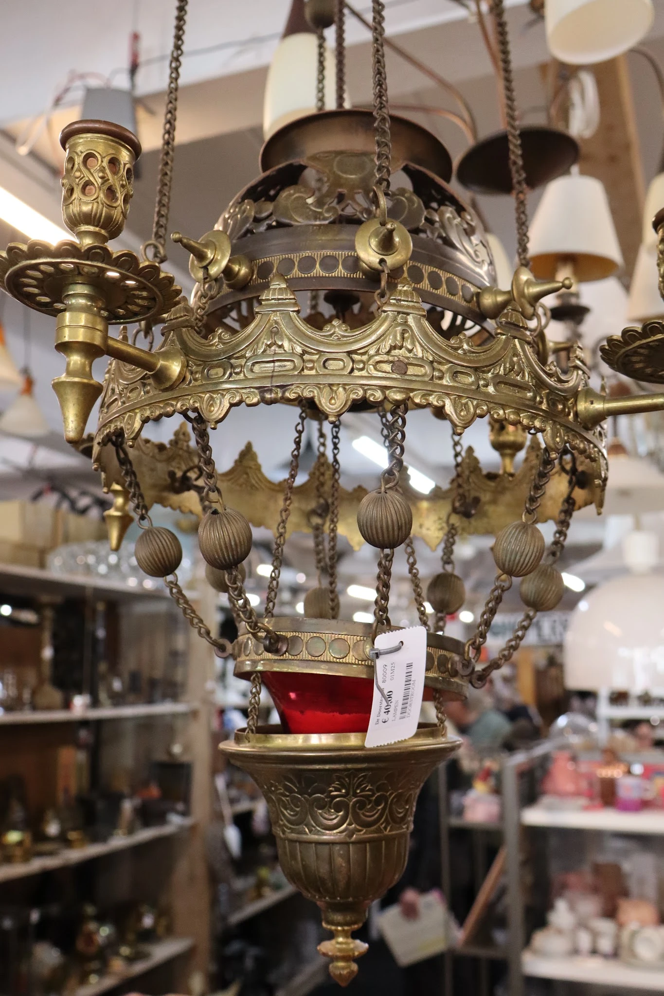 Goudkleurig decoratief hanglampje met ornamentale details en hangende bolletjes