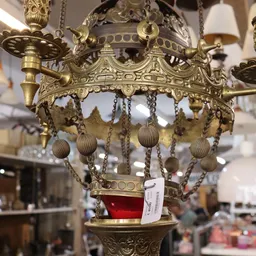 Goudkleurig decoratief hanglampje met ornamentale details en hangende bolletjes