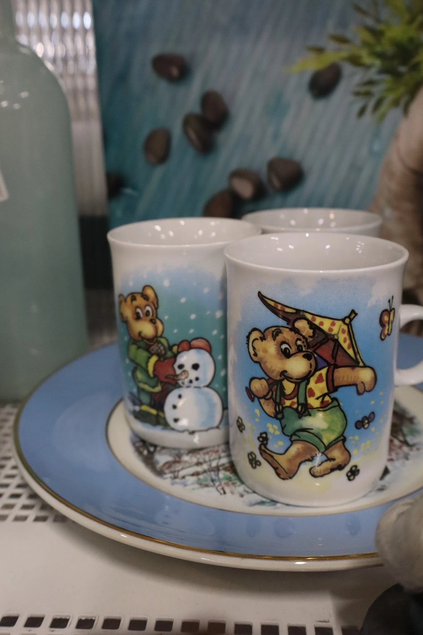 Drie witte plastic bekers met kleurige cartoonafbeeldingen van een beer en sneeuwpop
