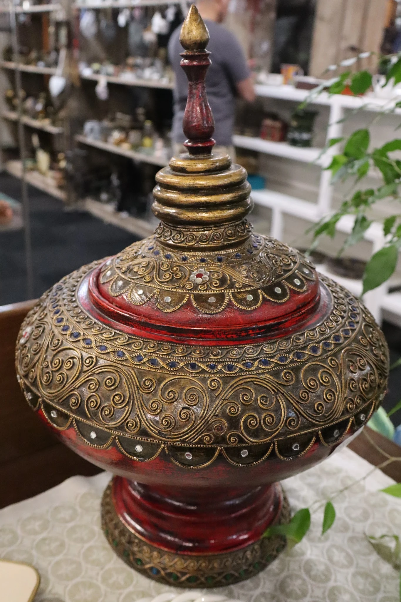 Goudkleurige decoratieve lampenvoet met ingewikkeld patroon en rode accenten