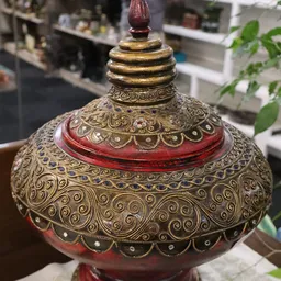 Goudkleurige decoratieve lampenvoet met ingewikkeld patroon en rode accenten