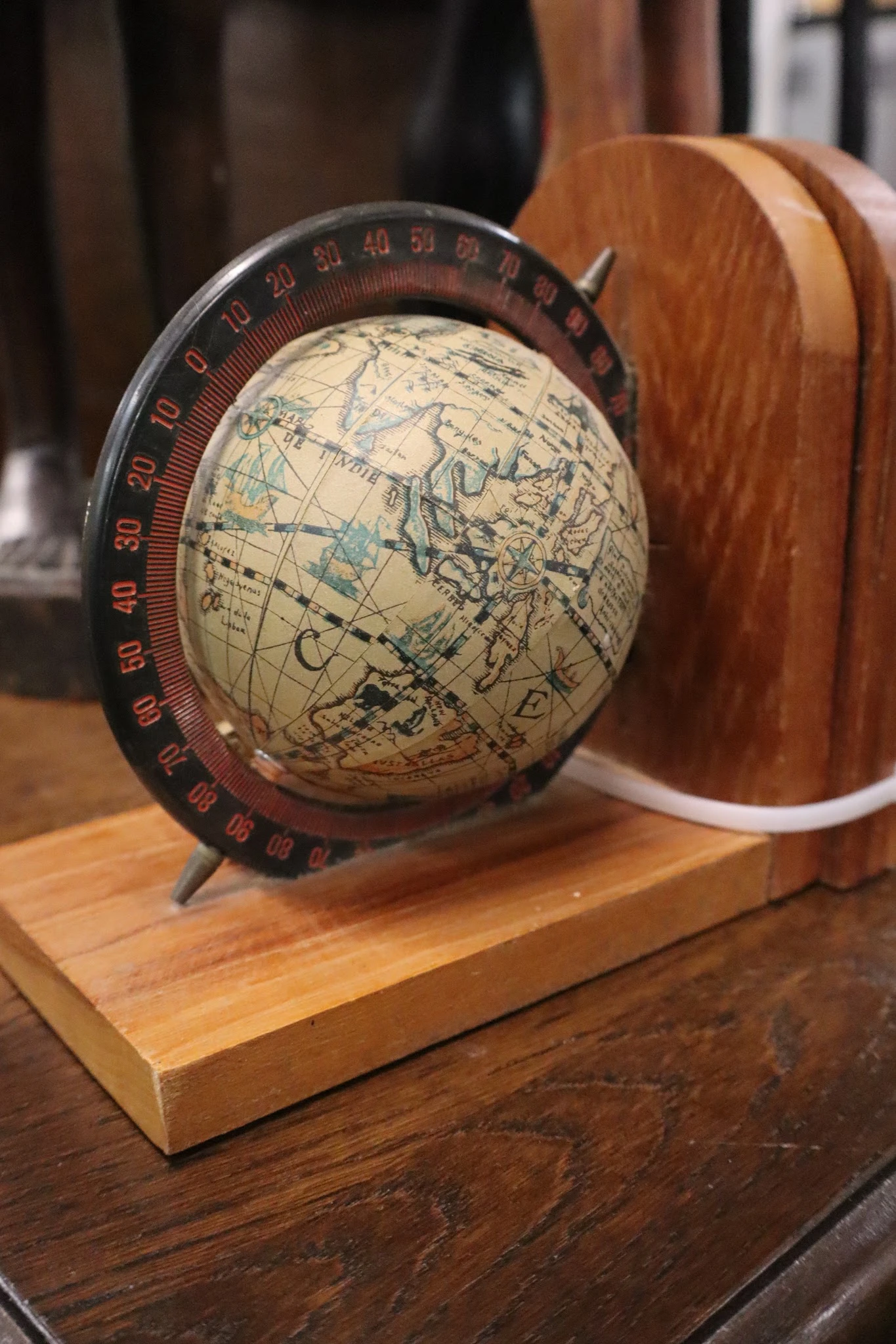 Vintage wereldbol met kaart van Europa en Azië op houten voet met rode gradenboog