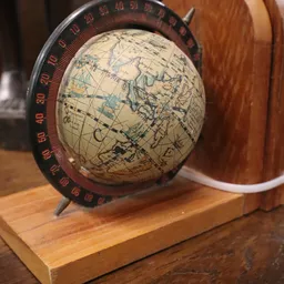 Vintage wereldbol met kaart van Europa en Azië op houten voet met rode gradenboog