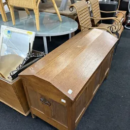 Houten dressoir of kast met gesloten deuren en houten blad, uitgestald in de kringloopwinkel