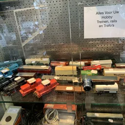 Vitrinekasten met miniatuurtreinen, rails en treinonderdelen in verschillende kleuren en formaten