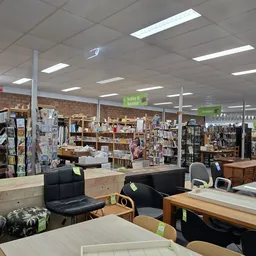Winkelvloer met tafels, stoelen en boeken in stellingen op de achtergrond
