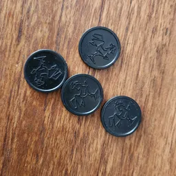 Vier zwarte munten met cartoonafbeeldingen op houten ondergrond