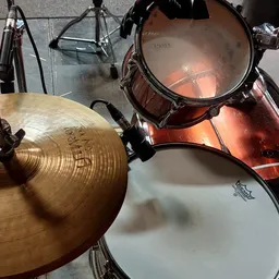 Drumstel met gouden cymbalen en rode trommels van bovenaf gefotografeerd