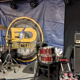 Drumkit met gele 'Electric River' drumkop op een podium met Marshall-versterker
