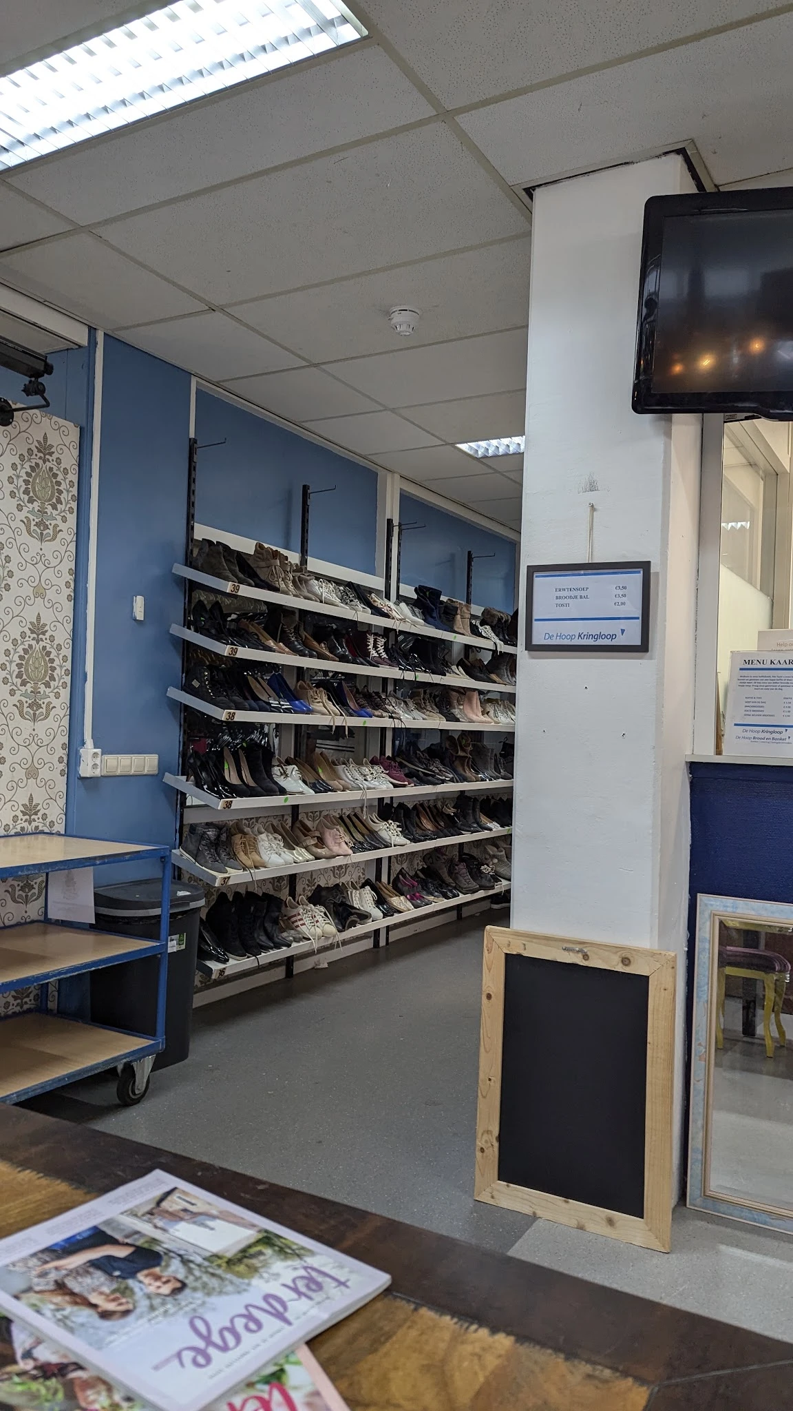 Rekken met groot assortiment tweedehands schoenen en laarzen in verschillende kleuren en maten
