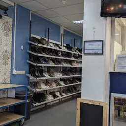 Rekken met groot assortiment tweedehands schoenen en laarzen in verschillende kleuren en maten