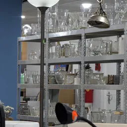 Metalen stellingkasten gevuld met glaswerk, servies en decoratieve artikelen