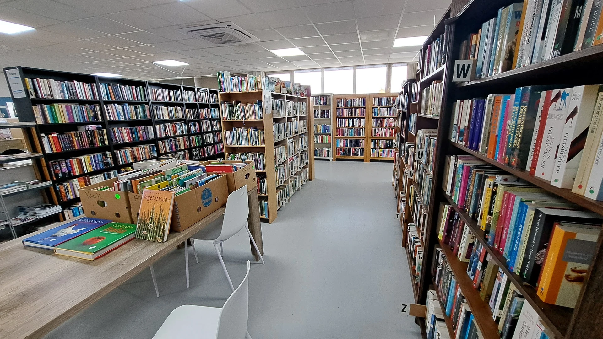 Boekenrekken en stellingen in een bibliotheek of boekenwinkel met uitgestalde boeken