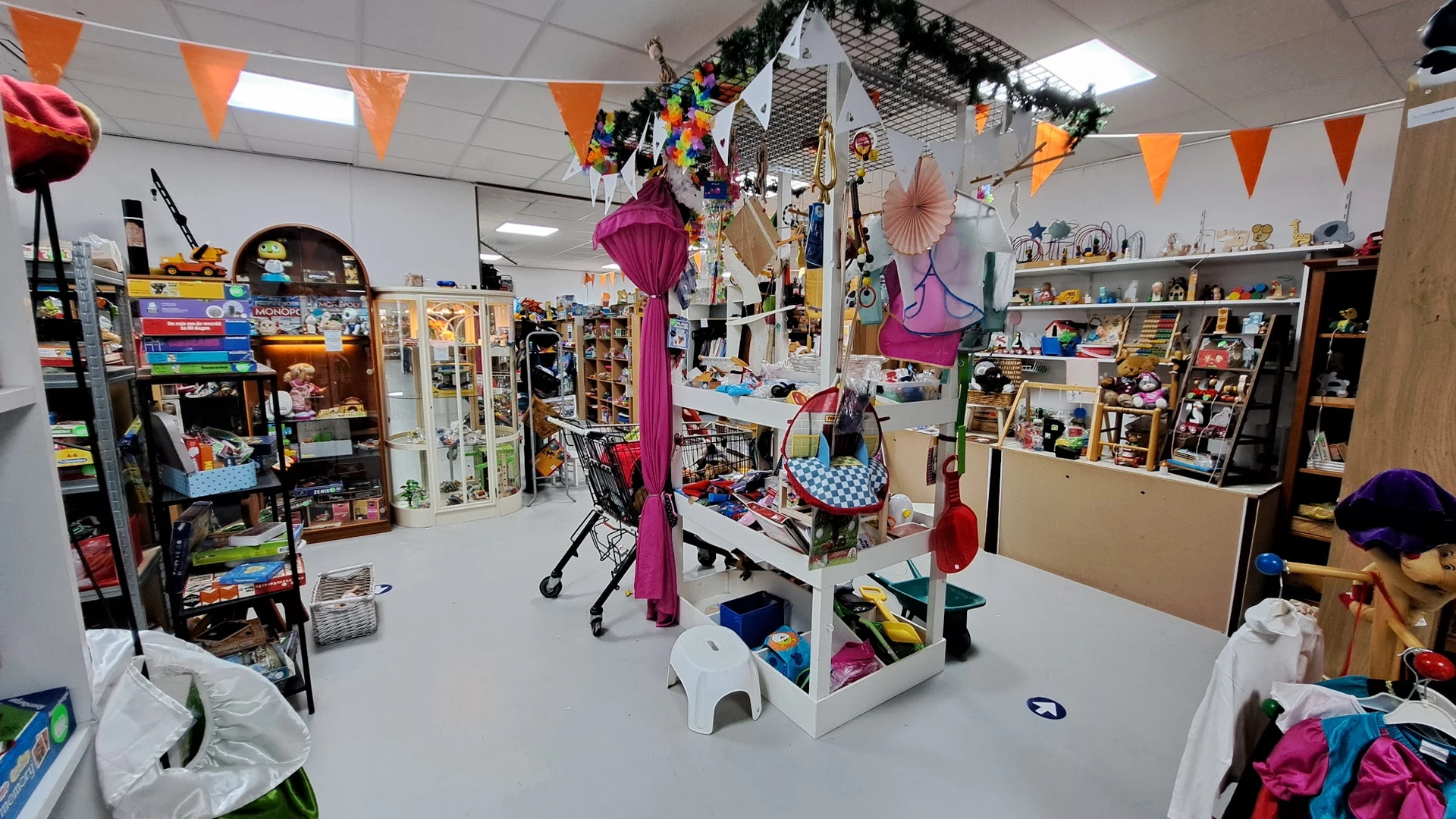 Winkelvloer met diverse speelgoed en decoraties, centrale display met ophangsysteem voor artikelen
